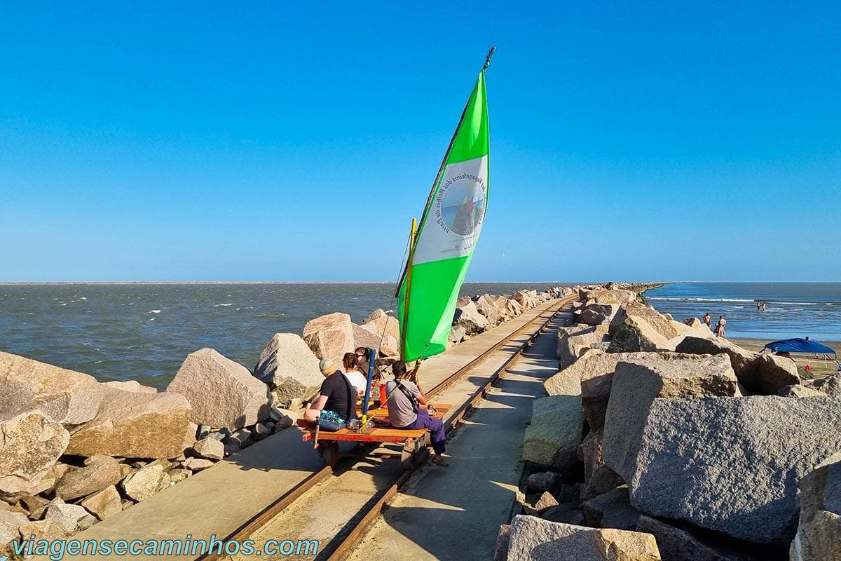 Trilhos das tradicionais vagonetas sobre os Molhes da Barra, estrutura de pedras que avança em direção ao oceano.